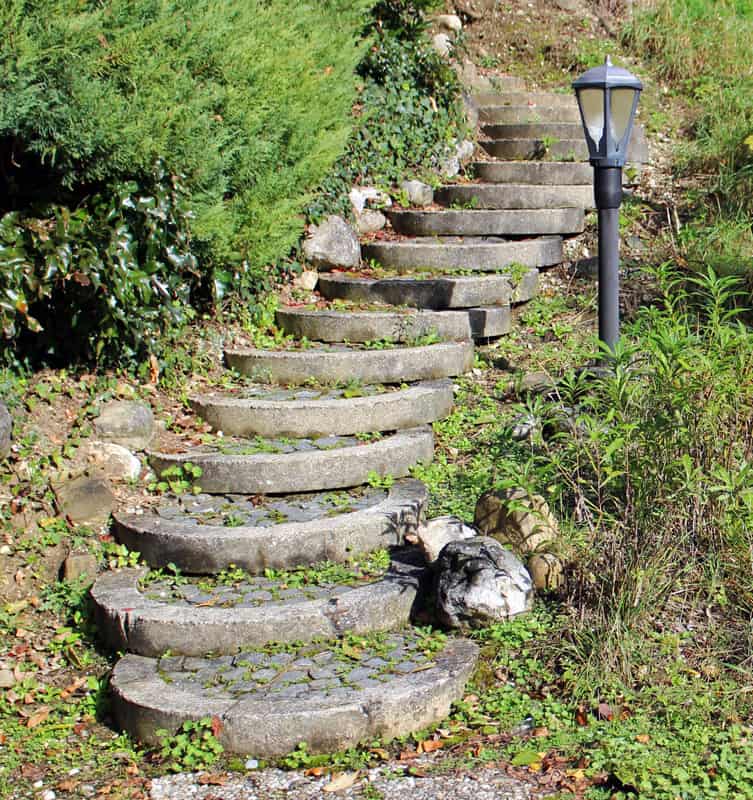 A stone staircase and lamp post on a hillside.